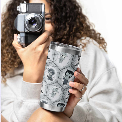 Woman in a white sweatshirt holding a vintage camera and the black and white monster tumbler