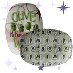 thumbnail of Two oval serving platters from the Olive My Friends Are Weird collection, one featuring retro illustrated olive characters with expressive faces on a mid-century pink and cream background, and one with a repeating olive portrait frame pattern in sage green