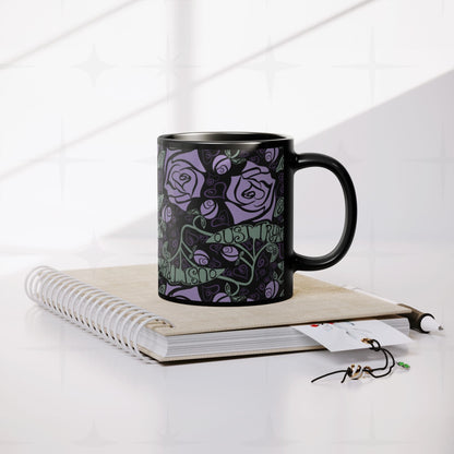 Anti-Trump hidden message black ceramic mug resting on spiral notebook with pen and accessories