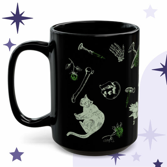 Toxic green goth mug in black ceramic with acid green Victorian engraving of a black cat, loose bones, a skull, and a rose