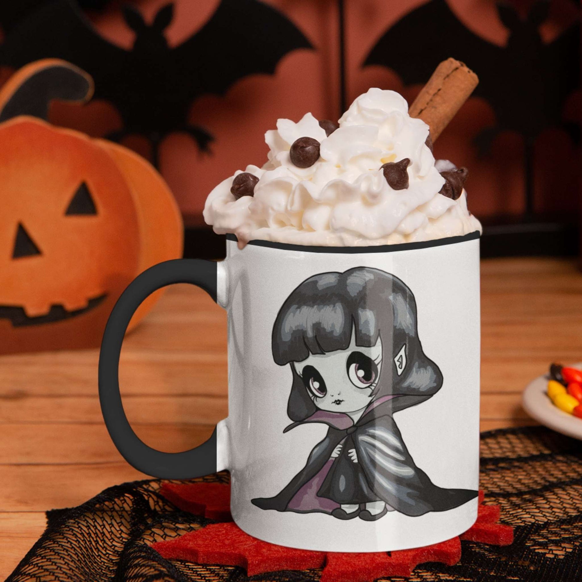 Vampire chibi mug with whipped cream and cinnamon on a Halloween table with pumpkin and bats