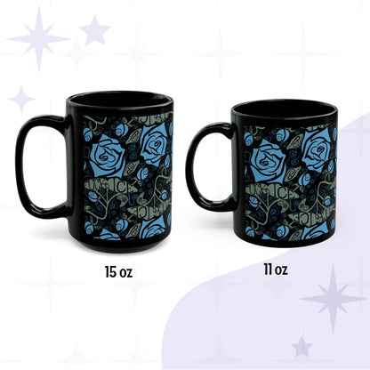 Side-by-side size comparison of dark floral activist coffee mug in 11oz and 15oz, glossy black ceramic with cornflower blue botanical rose pattern and hidden anti-ICE message in sage green leaves