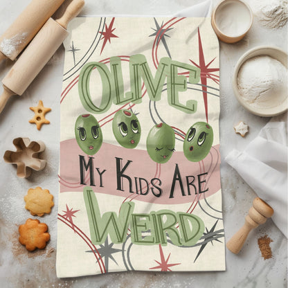 Funny olive pun kitchen tea towel on marble surface with baking props, retro mid-century illustration with sage green lettering and atomic starburst design