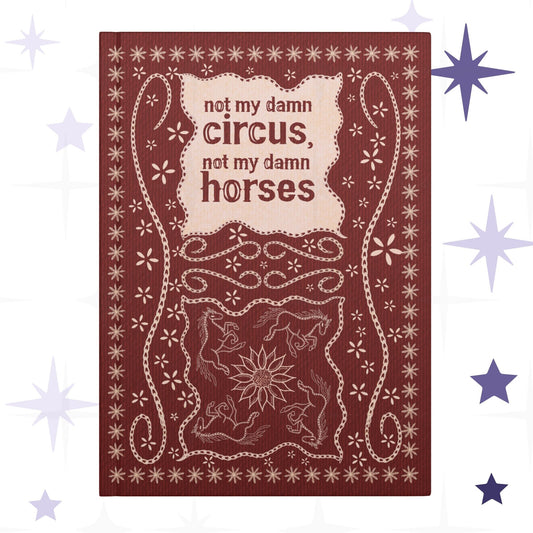 Funny western hardcover journal with hand-lettered text reading not my damn circus not my damn horses in stitched leather effect on deep burgundy cover with folk art horses and sunflower