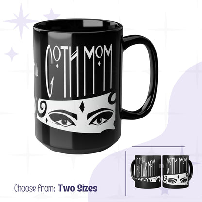 Glossy black goth mom coffee mug with Art Deco gothic hand lettering reading Goth Mom above illustrated dramatic eyes on white band, 15oz ceramic, two sizes shown
