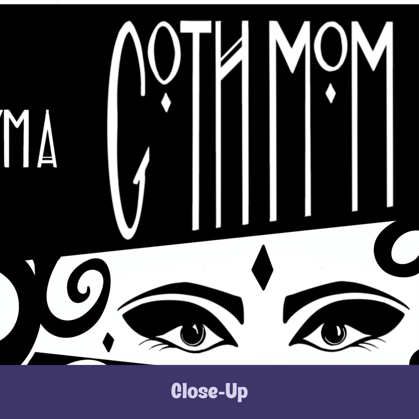 Close-up of gothic coffee mug showing Goth Mom lettering above hand-drawn masquerade-style eyes with winged liner and diamond gem on white band on black ceramic