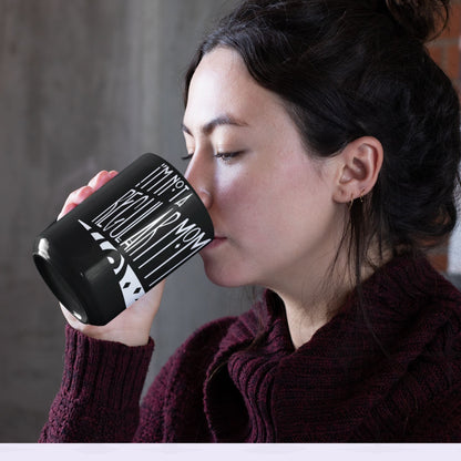 Woman with dark hair drinking from black goth mom mug showing I'm Not a Regular Mom gothic lettering, 11oz ceramic coffee cup