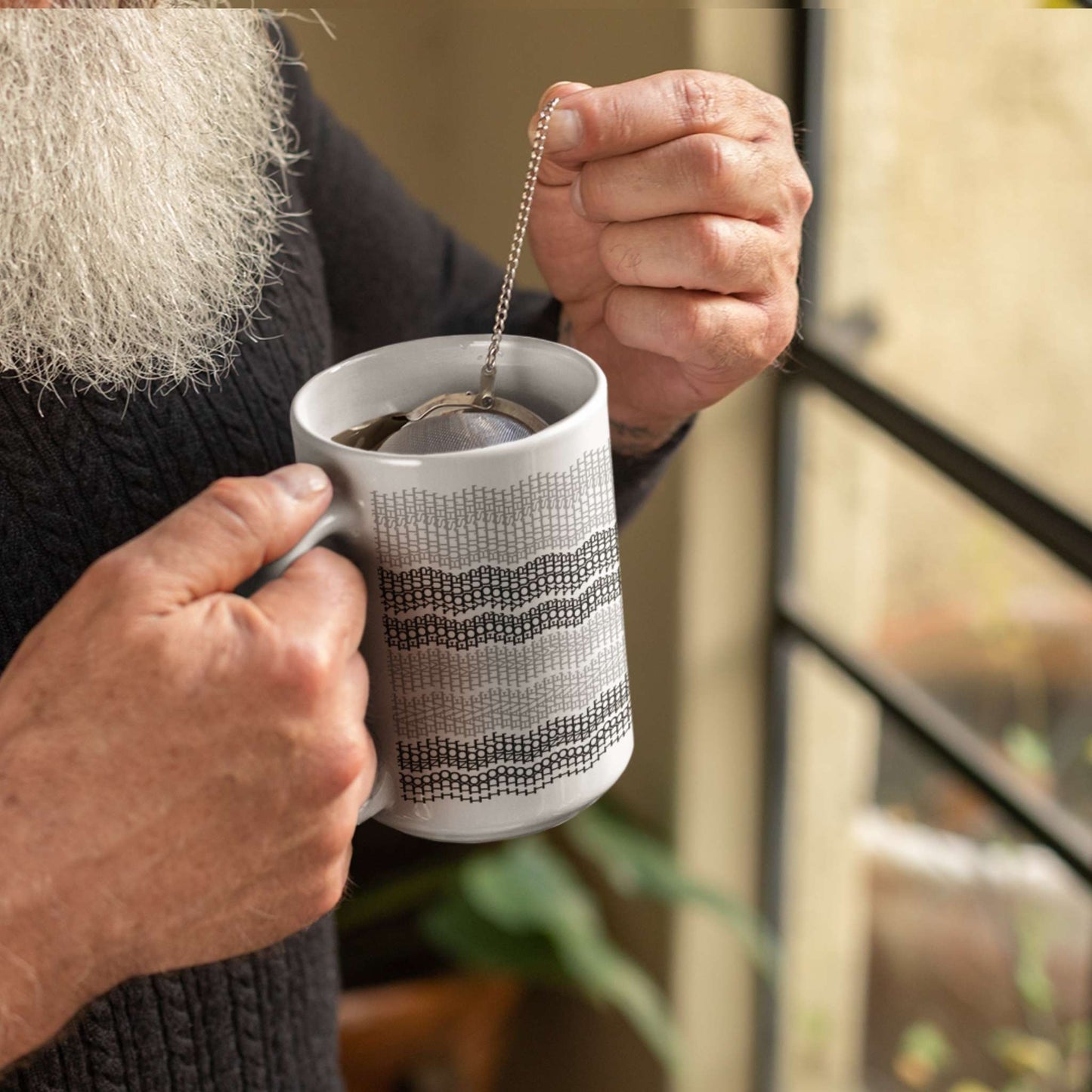 Person with white beard brewing loose-leaf tea in gray stripes hidden message embroidery mug