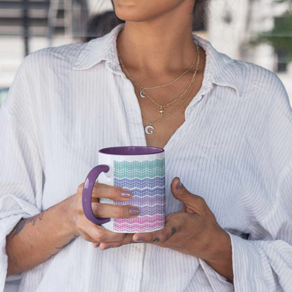 Woman in a white pinstripe shirt and moon necklaces holding a purple accent hidden message mug with both hands
