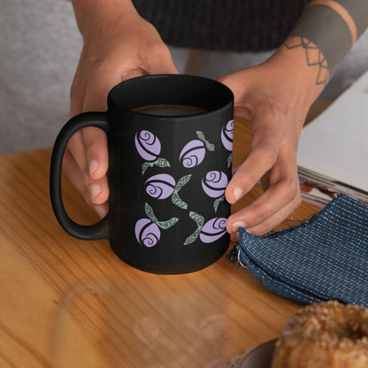 Hot pink hidden message political mug on rustic wooden table with a tea infuser being lowered in and a plate of jam toast alongside, floral protest design on black ceramic