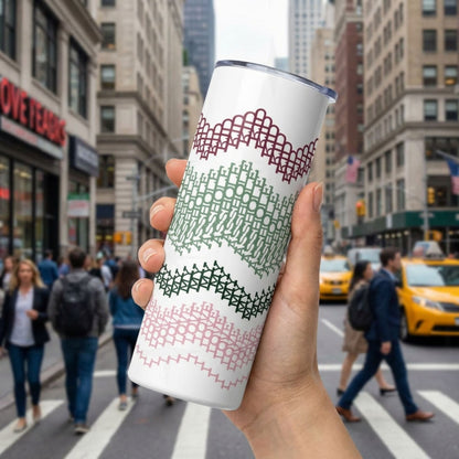 Preppy Stripes hidden message tumbler held up on a busy city street — burgundy, sage green, dark forest green, and blush pink chevron band pattern wraps the white 20oz skinny tumbler