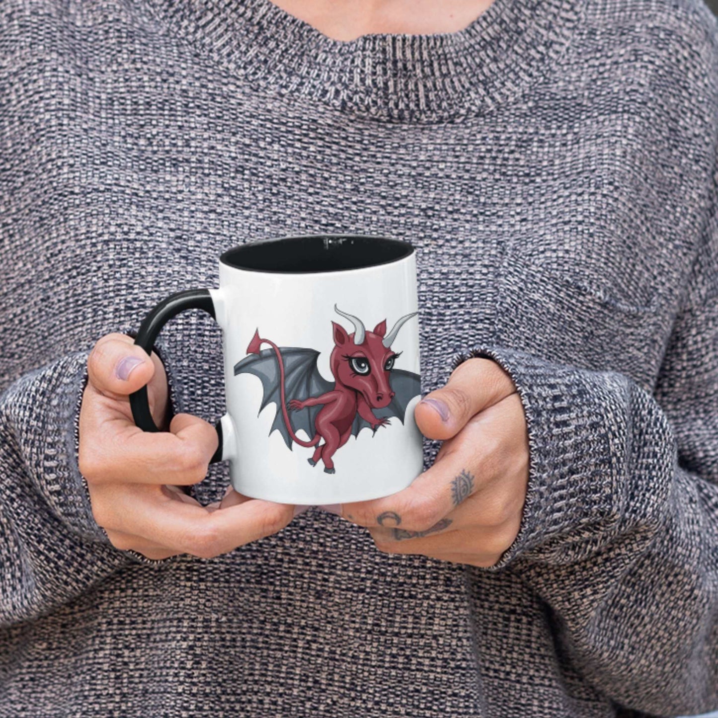 Person in a gray sweater holding the cute Jersey Devil cryptid coffee mug