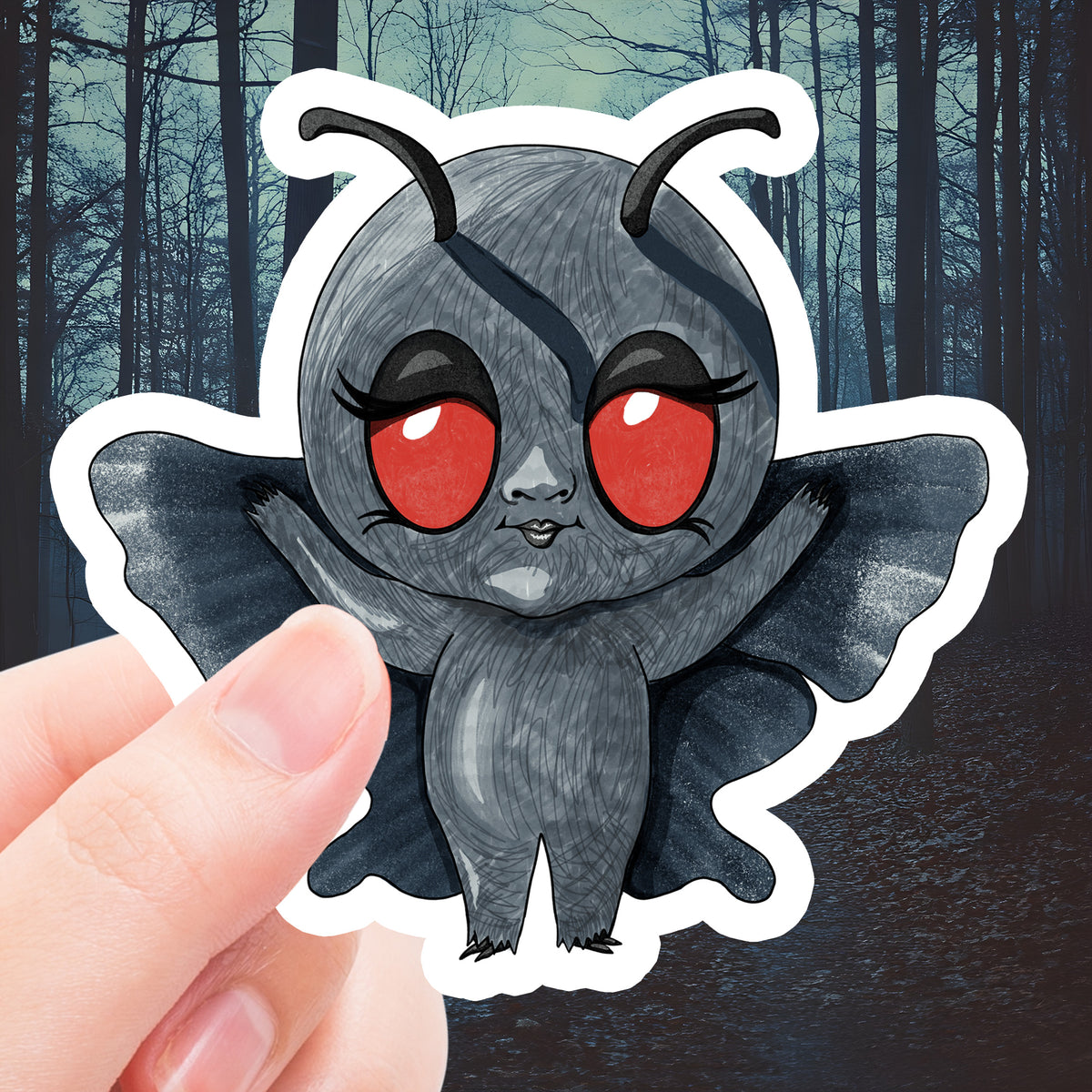Fingers holding the chibi Mothman sticker with red eyes, curved antennae, and spread gray wings
