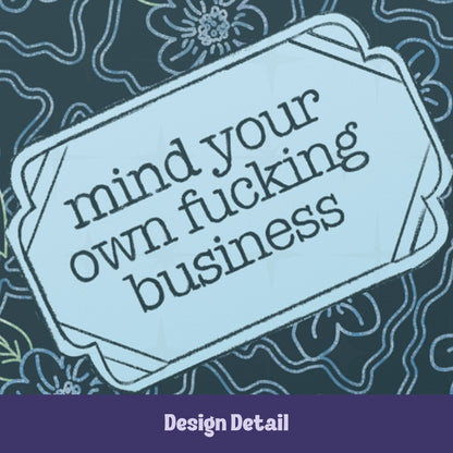 Close-up of scalloped Art Deco label on profanity journal cover showing mind your own fucking business in lowercase serif type against pale ice blue background