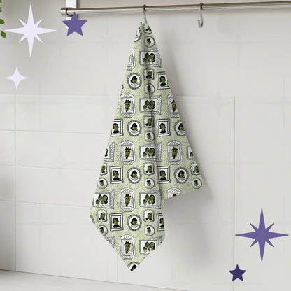 Sage green retro olive portrait tea towel hanging from silver kitchen hook against white tile backsplash