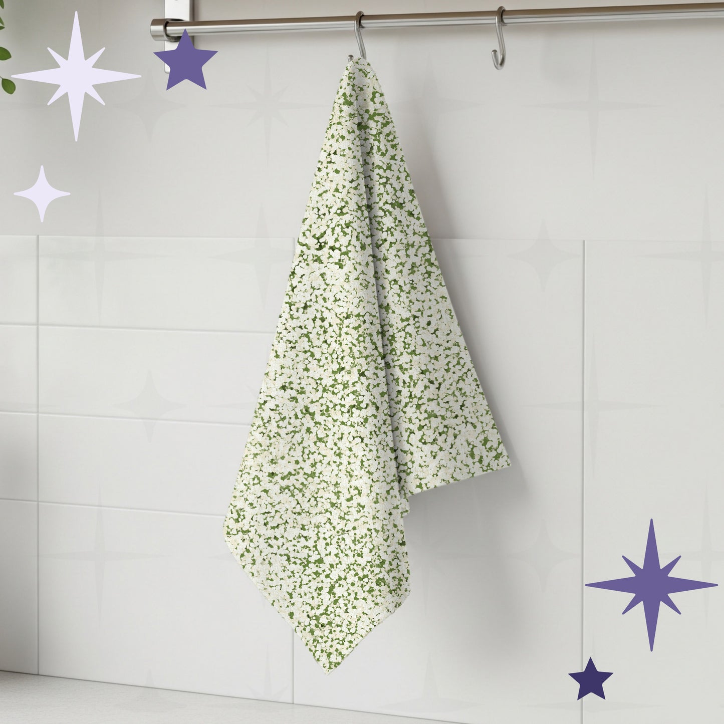 Sage green terrazzo print tea towel hanging from stainless steel rail hook on white tile kitchen wall