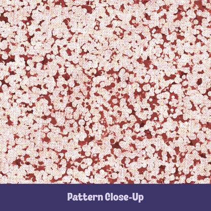 Close-up of terracotta red terrazzo pattern showing rounded cream pebble cluster shapes on brick red cotton twill ground