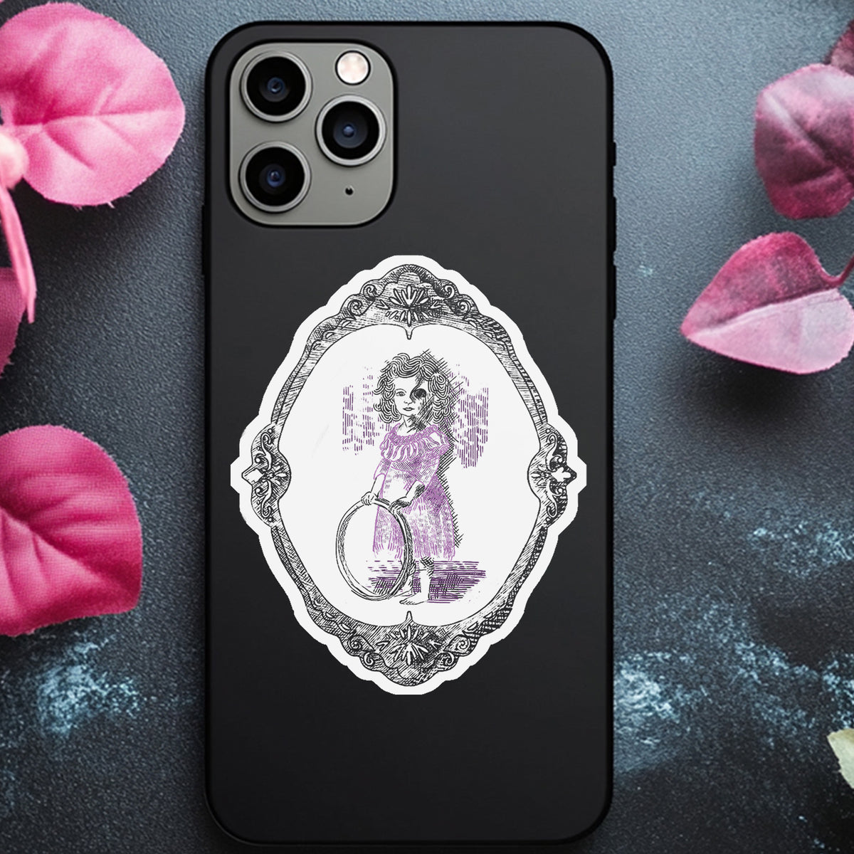 Creepy victorian girl sticker on the back of a black phone case surrounded by pink petals
